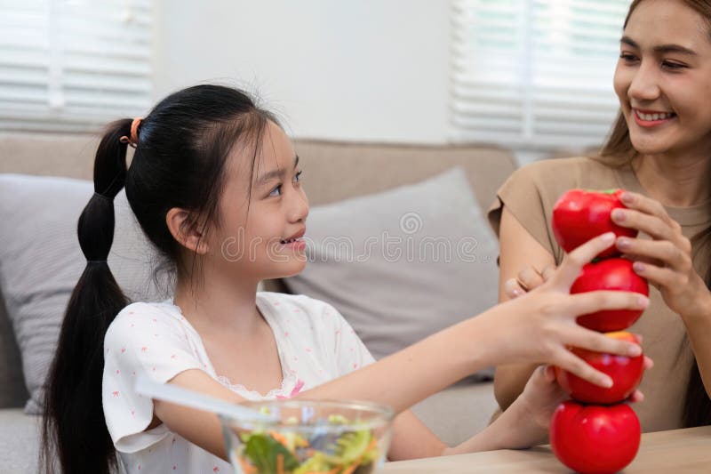 Wellness fun: Mother and daughter stacking apples for healthy snacks stock images