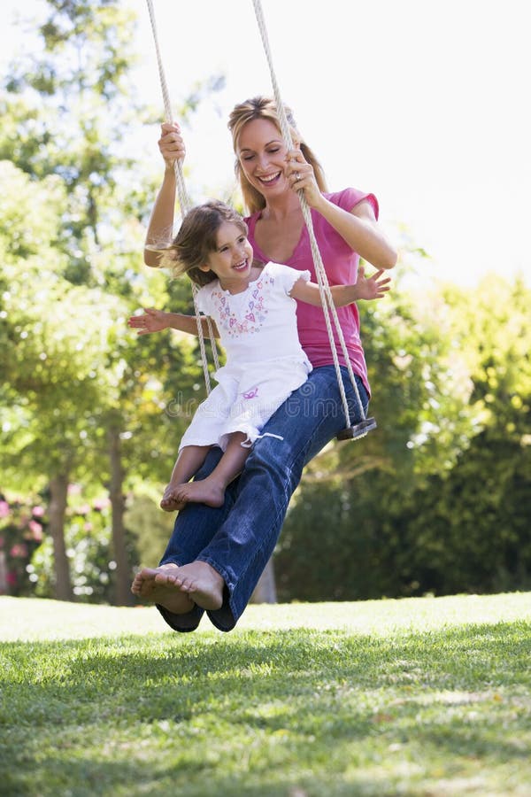 Mother and daughter on garden swing stock photo