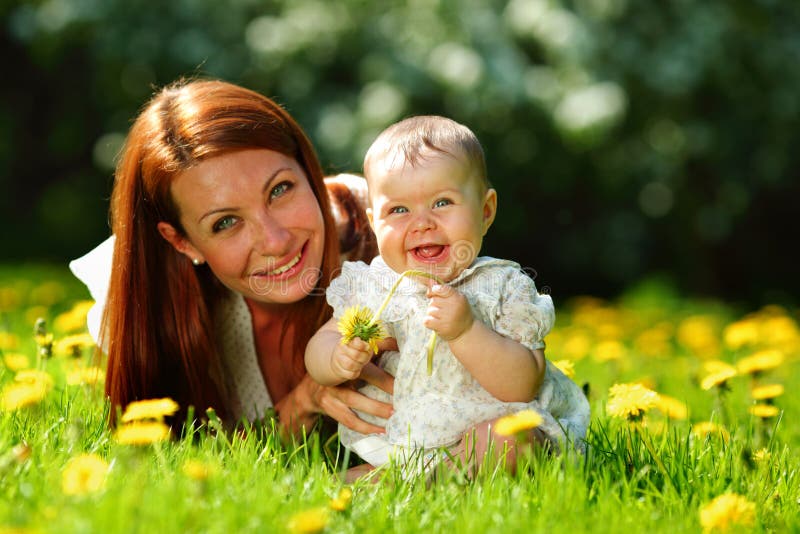 Happy mother and daughter on the green grass