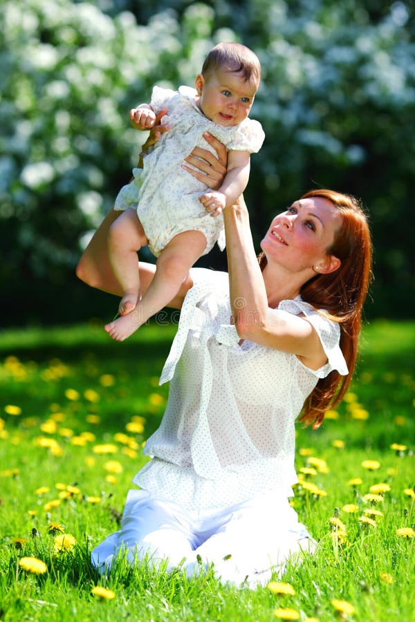 Happy mother and daughter on the green grass