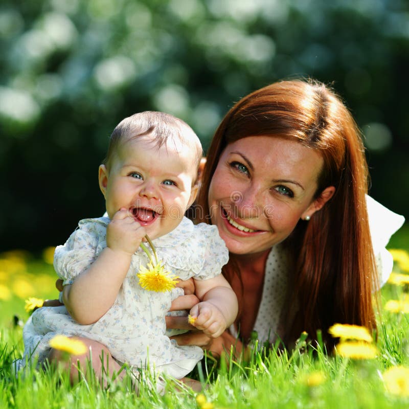 Happy mother and daughter on the green grass