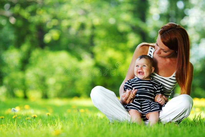 Happy mother and daughter on the green grass