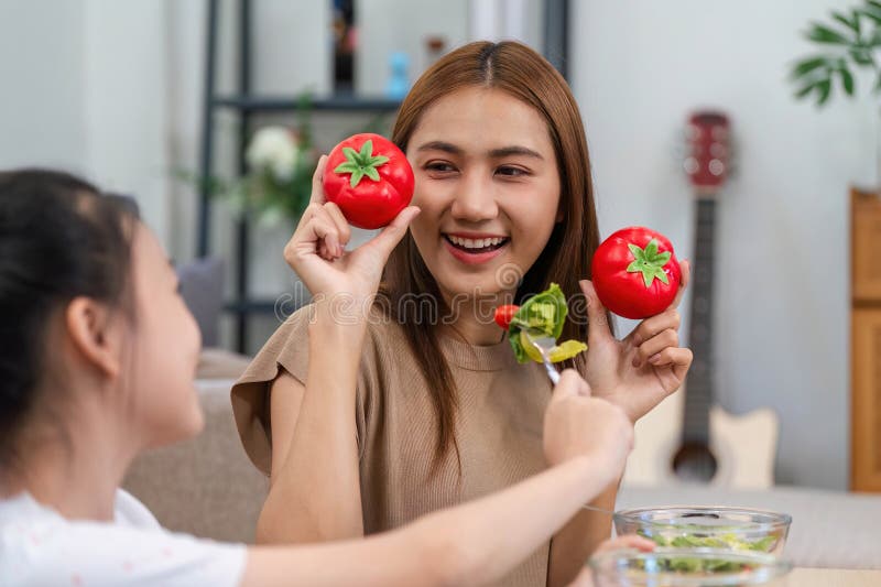 Wellness and joy: Mother and daughter enjoying fresh tomatoes together royalty free stock photography