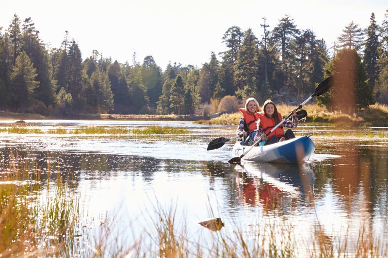 Mother and daughter kayaking on lake, front view royalty free stock photography