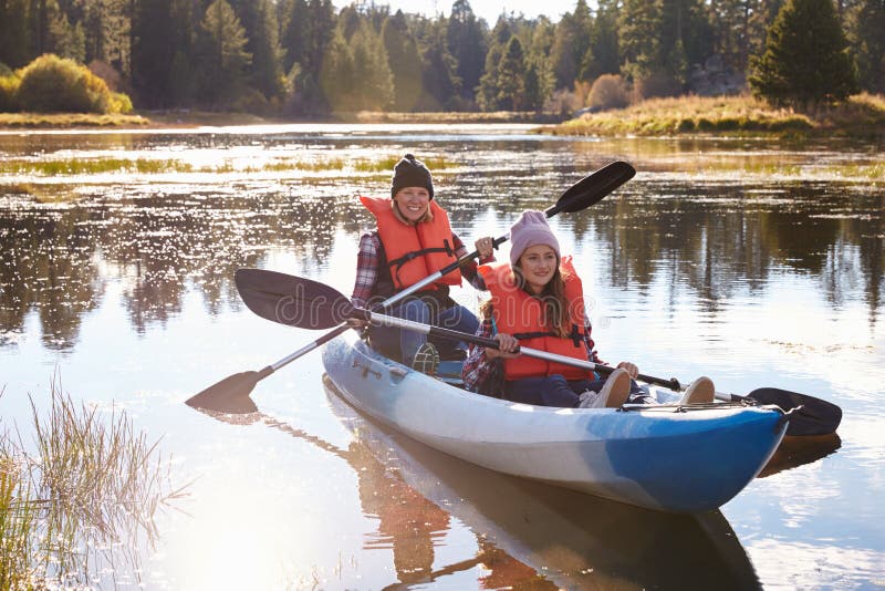 Mother and daughter kayaking on lake, front view, close-up stock photography