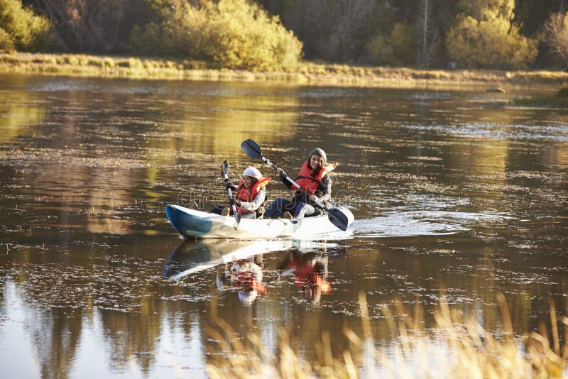 Mother and daughter kayaking together on a lake, front view stock image
