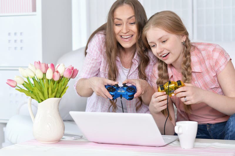 Mother and daughter playing on laptop