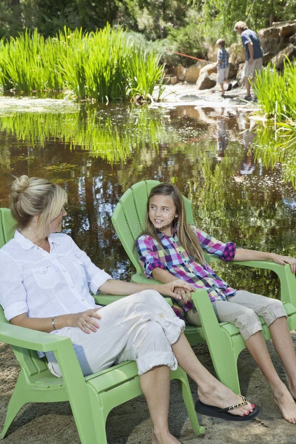 Mature Woman Resting in Chair with Man and Son Fishing in the ...