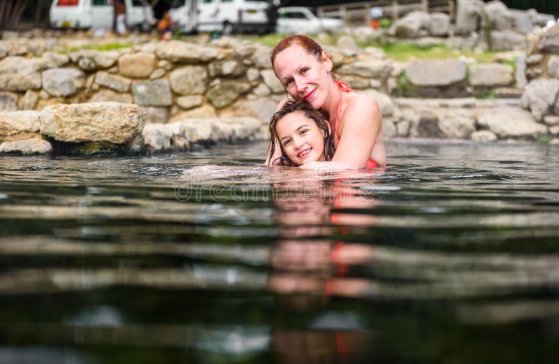 Mother and daughter relaxing in natural thermal water roman spa