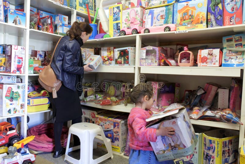 Mother and child selecting toys in toy library.Toy libraries offer wide range of toys appropriate for children at different development stages without family need to buy them. Mother and child selecting toys in toy library.Toy libraries offer wide range of toys appropriate for children at different development stages without family need to buy them.