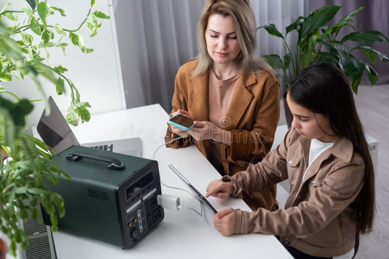 Mother and Daughter Use a Portable Charging Station Stock Image Image