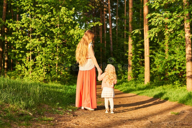 The Eldest Daughter Walks Down The Flower Path Mother and Daughter Walk Along a Path in a Park Stock Image - Image of