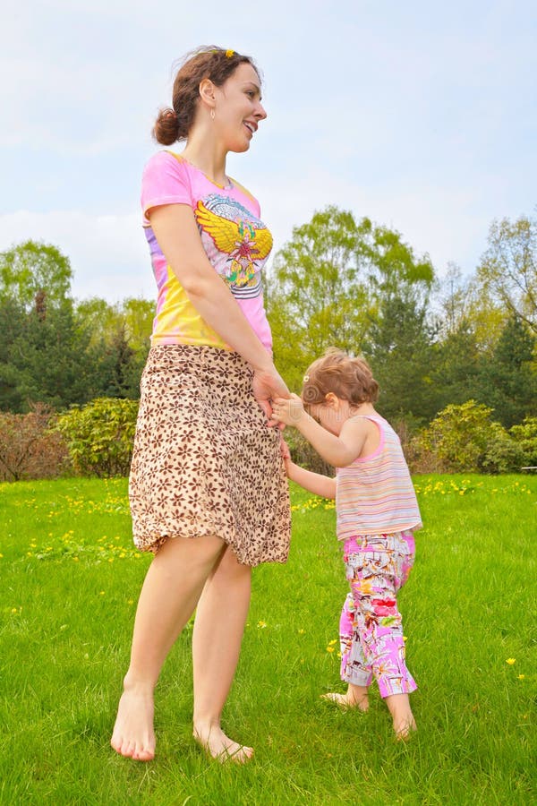 Mother with daughter walk barefoot