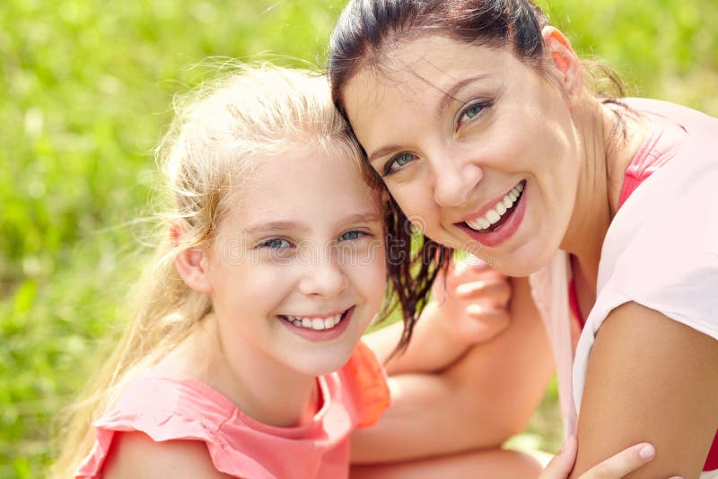 Hugging happy mother and daughter for a walk in the park 