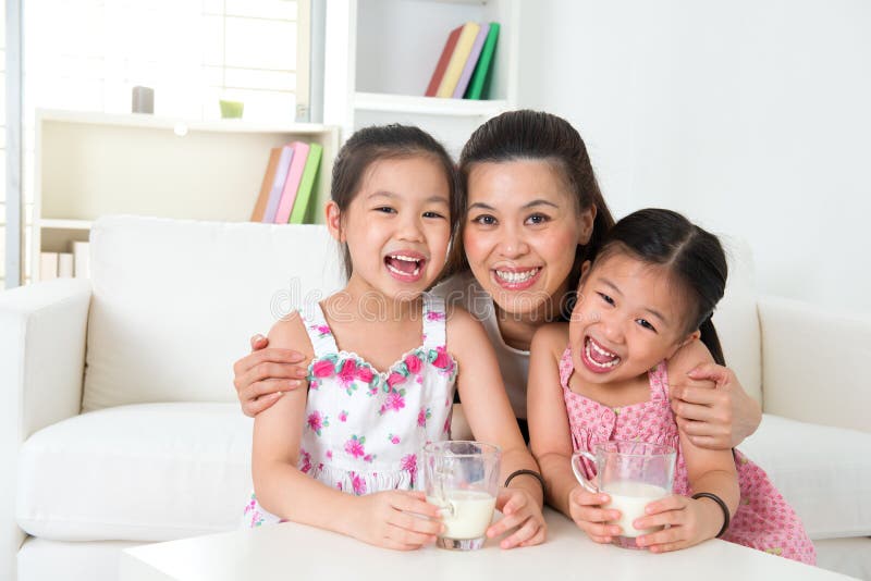 Mother and daughters drinking milk stock image Mother and daughters drinking milk stock image
