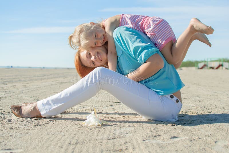 Madre e figlia giocare riva del mare in estate.