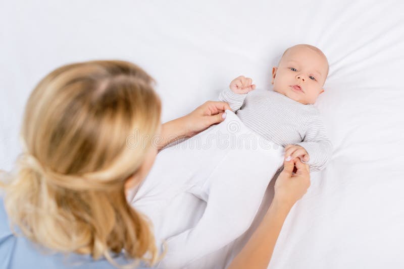 Mother dressing baby stock photo. Image of together 109989268