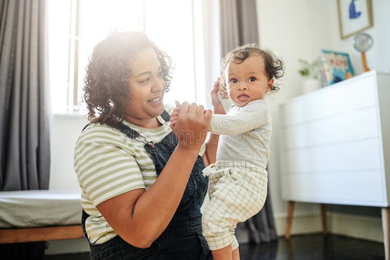 Mother, family and baby holding hands in bedroom for love, care and development. Woman and curious boy child or toddler royalty free stock photo