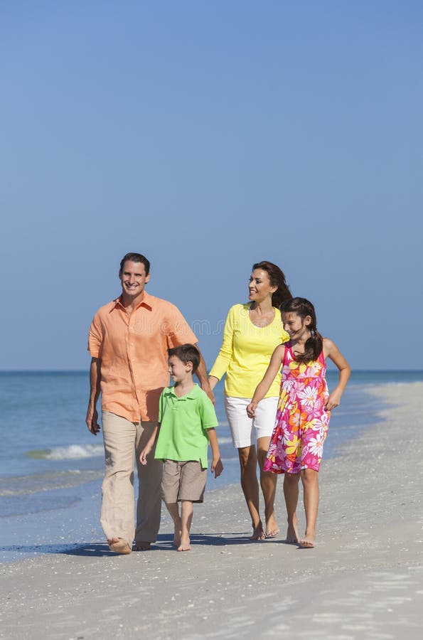 Mother, Father and Children Family Walking On Beach