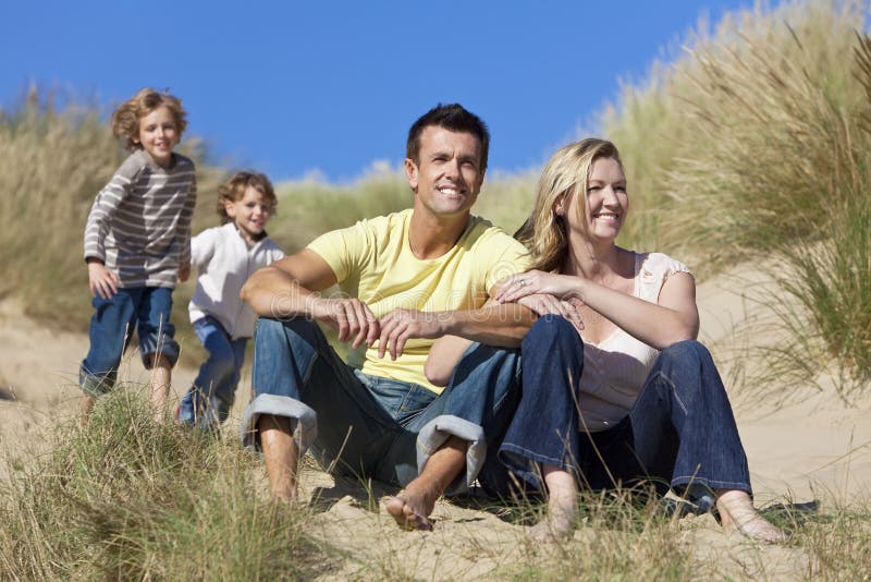 Glückliche familie aus Mutter, zwei söhne, spaß haben dünen aus sonnig Strand.