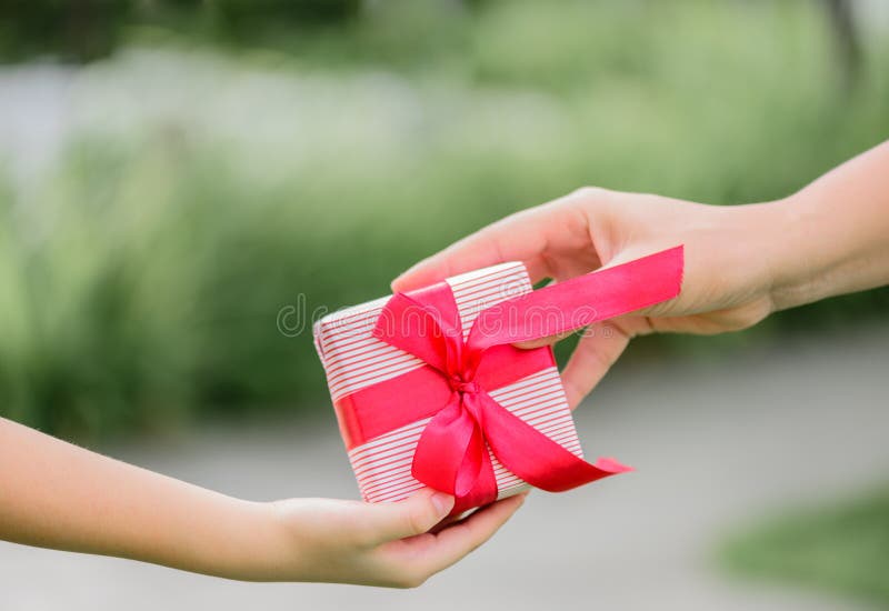 Mother hand giving a gift box to her child. Holidays, present, royalty free stock images Mother hand giving a gift box to her child. Holidays, present, royalty free stock images