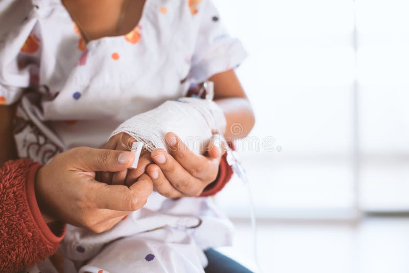 Mother hand holding sick daughter hand who have IV solution stock photography Mother hand holding sick daughter hand who have IV solution stock photography