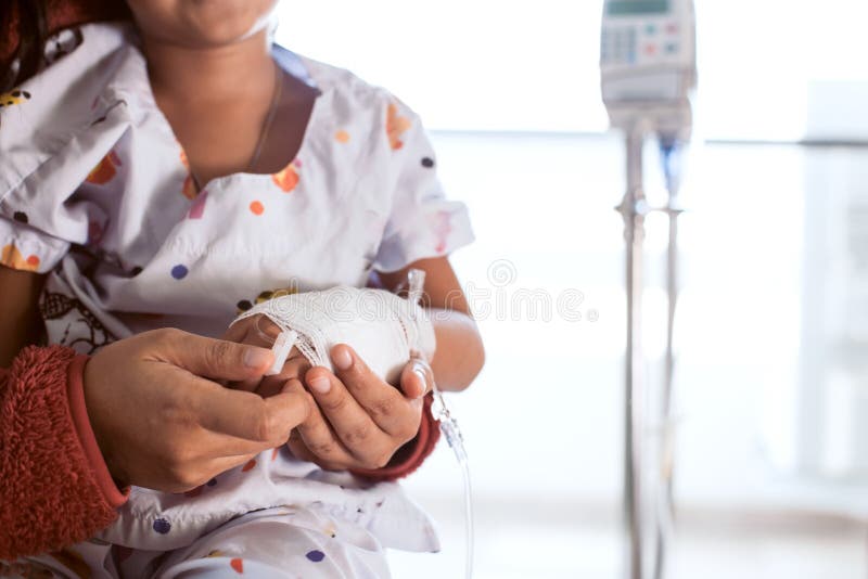 Mother hand holding sick daughter hand who have IV solution stock photo Mother hand holding sick daughter hand who have IV solution stock photo