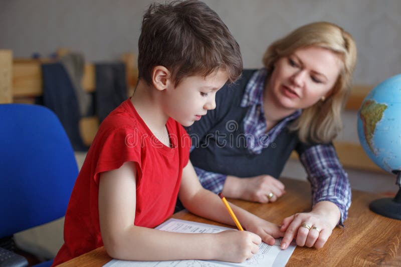 Mother helps son writing homework stock photo Mother helps son writing homework stock photo