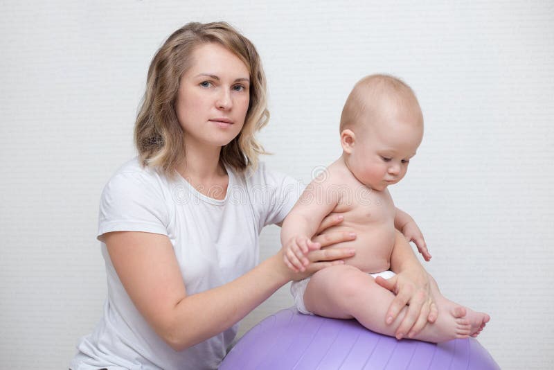 Mother and her baby doing exercises on a ball stock photos Mother and her baby doing exercises on a ball stock photos