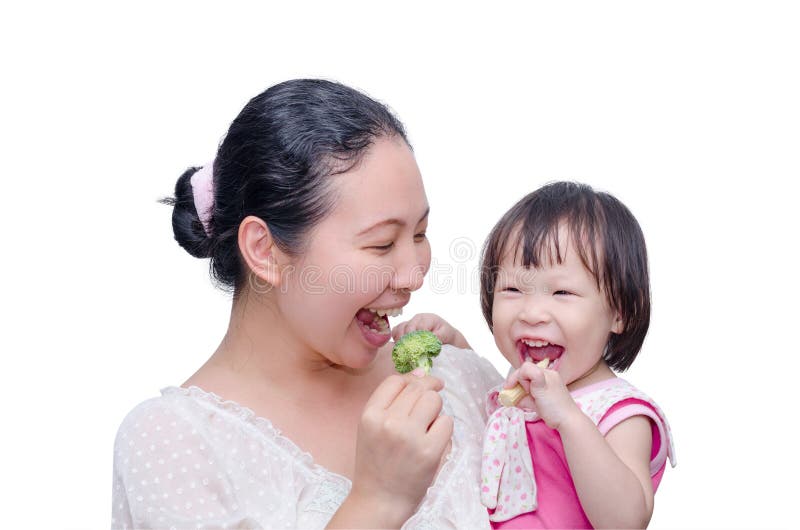 Mother and her daughter eating vegetables