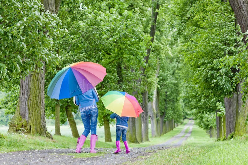 Mother and her daughter with umbrellas