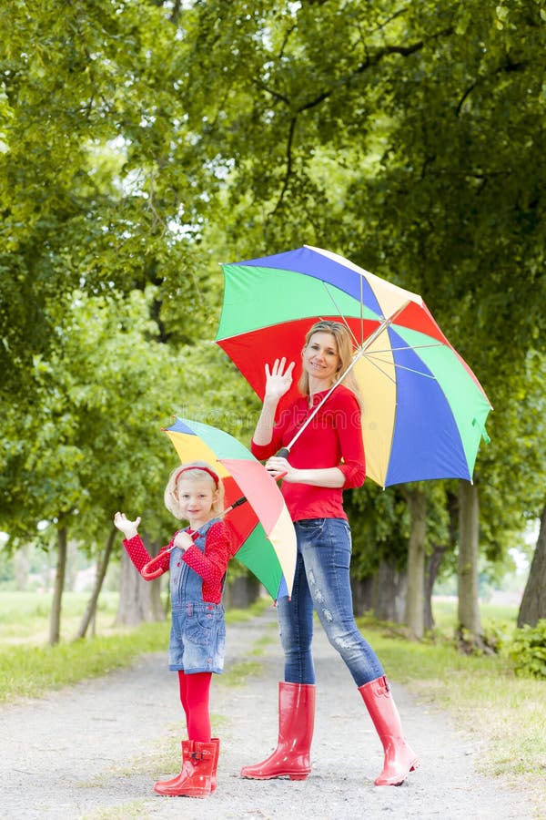 Mother and her daughter with umbrellas