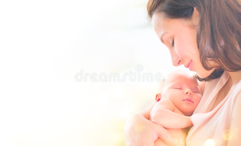Mother and her newborn baby together. Happy mother and baby kissing and hugging. Maternity concept