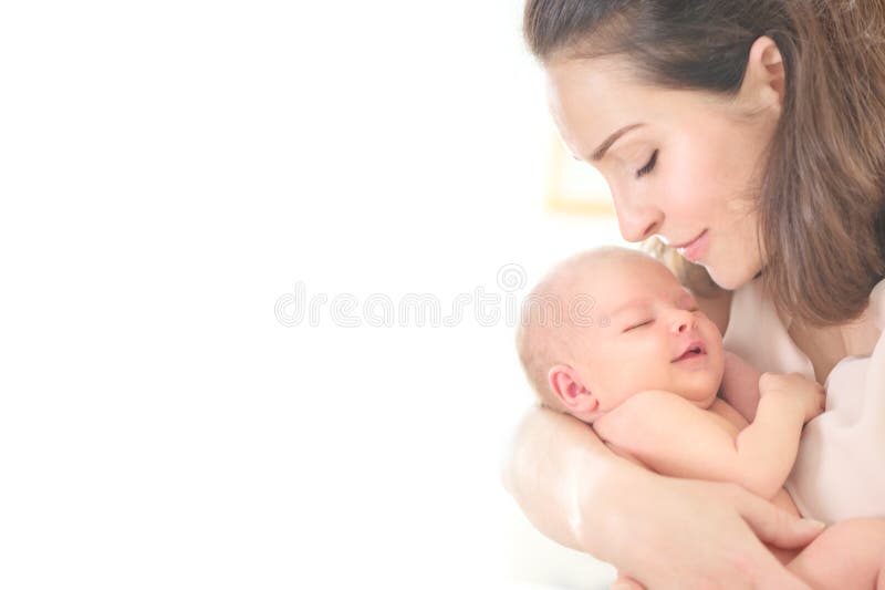 Mother and her Newborn Baby together. Love. Happy Mother and Baby kissing and hugging. High key soft image of Beautiful Family