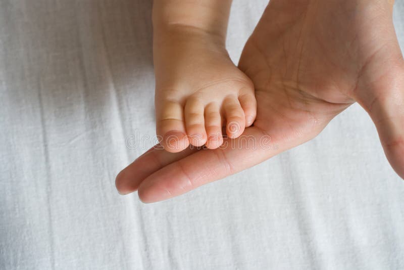 Mother is holding baby foot