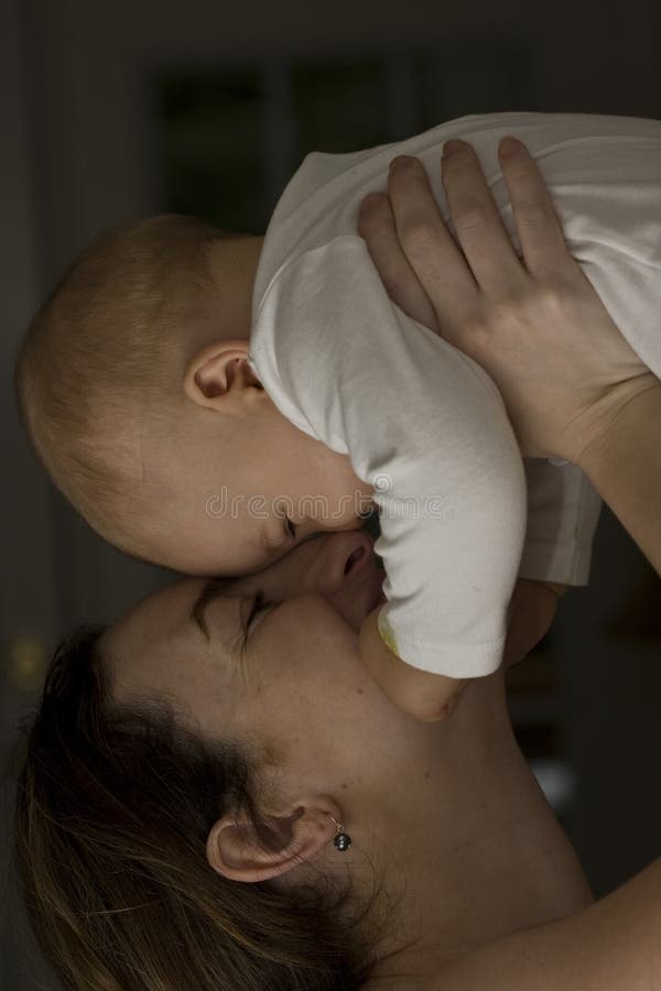 Mother holding baby to the sky and laughing