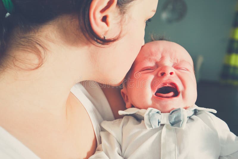 Mother holding crying baby stock photo Mother holding crying baby stock photo