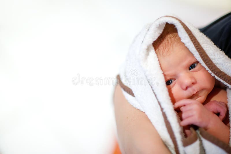 Mother holding her newborn baby daughter after birth on arms.