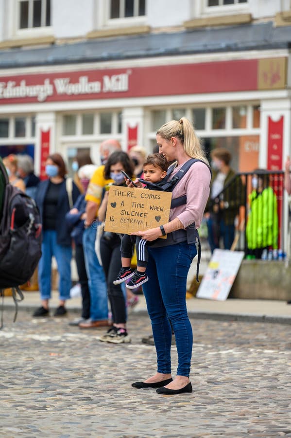 A mother holds a young child and a homemade sign at a Black Lives Matter protest in Richmond North Yorkshire stock photography A mother holds a young child and a homemade sign at a Black Lives Matter protest in Richmond North Yorkshire stock photography
