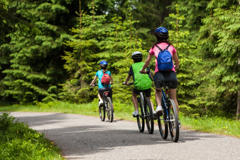 Mother and kids biking in forest. Mother and kids biking in forest