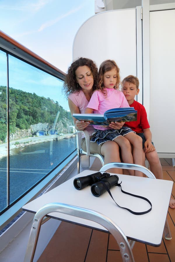 Mother, kids consider book on ship deck