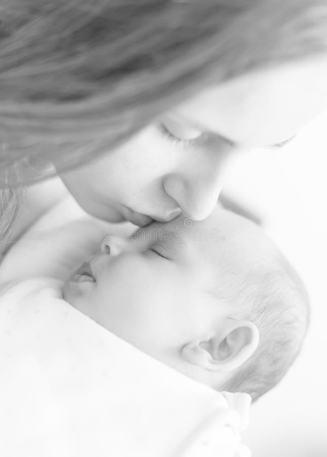 Mother kissing her newborn