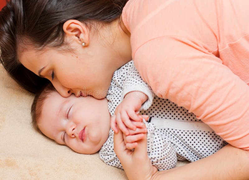 Целую маму спящую. Мама целует новорожденного. Взрослая женщина целует новорожденного дома. Фото мама с малышом в пелёнках только. Фото матери целующе новорождённого.