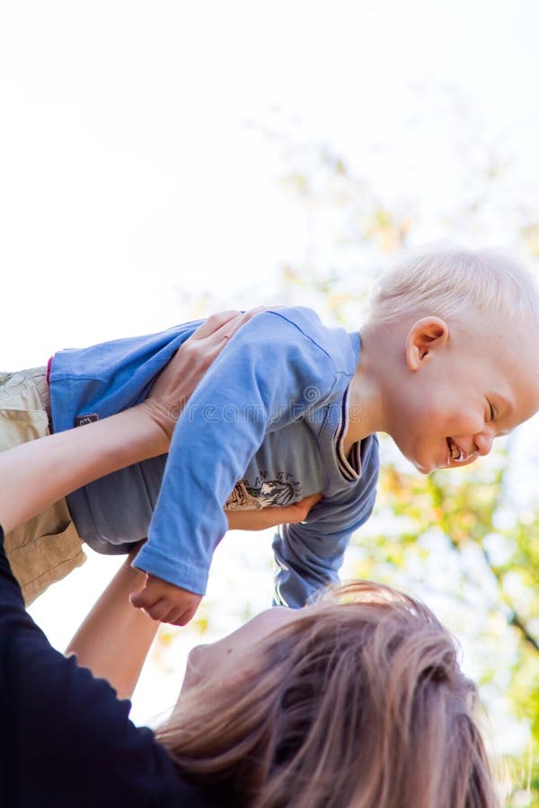 Mother lifting up her cute son stock image Mother lifting up her cute son stock image