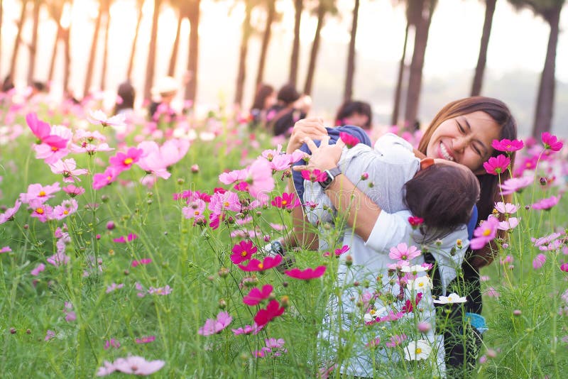 Mother and little daughter playing together in flower royalty free stock images Mother and little daughter playing together in flower royalty free stock images