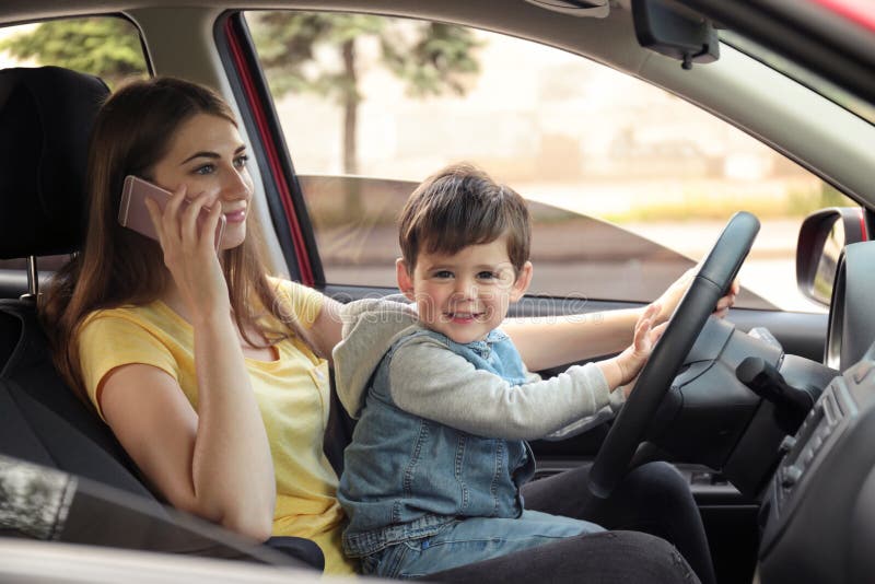 https://thumbs.dreamstime.com/b/mother-little-son-knees-driving-car-talking-phone-child-danger-151644484.jpg