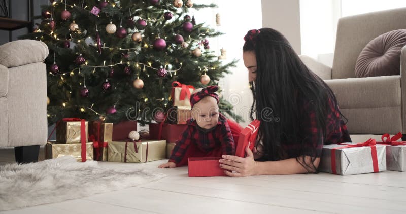 Mother opening Christmas gift for baby daughter