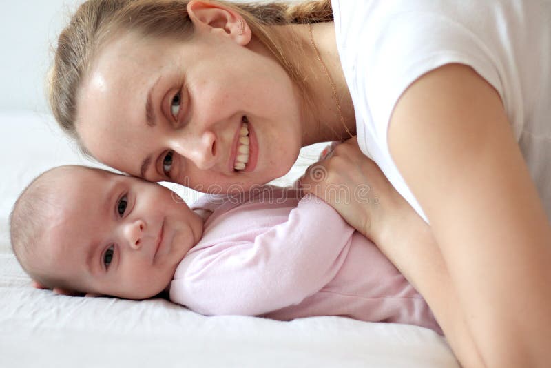 Mother playing with baby and smiling on camera stock image