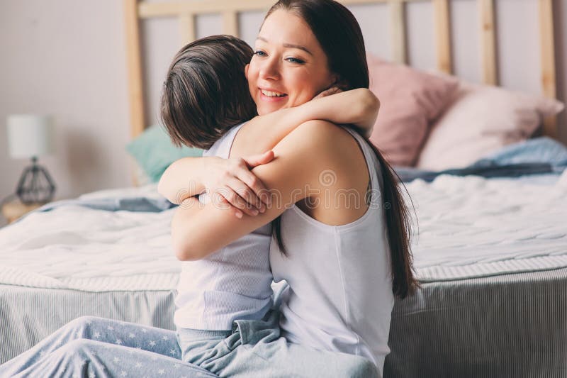 Mother playing with child son in bedroom. Happy family wearing pajamas royalty free stock image Mother playing with child son in bedroom. Happy family wearing pajamas royalty free stock image