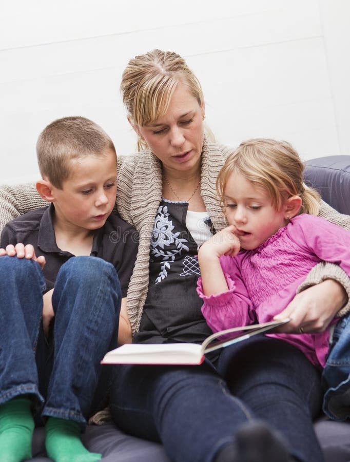 Mother reading a book to her children